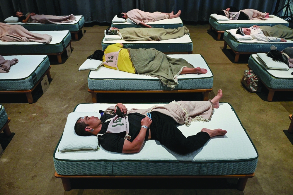 Attendees take part in a sleep competition organised by a mattress brand in Tokyo — AFP