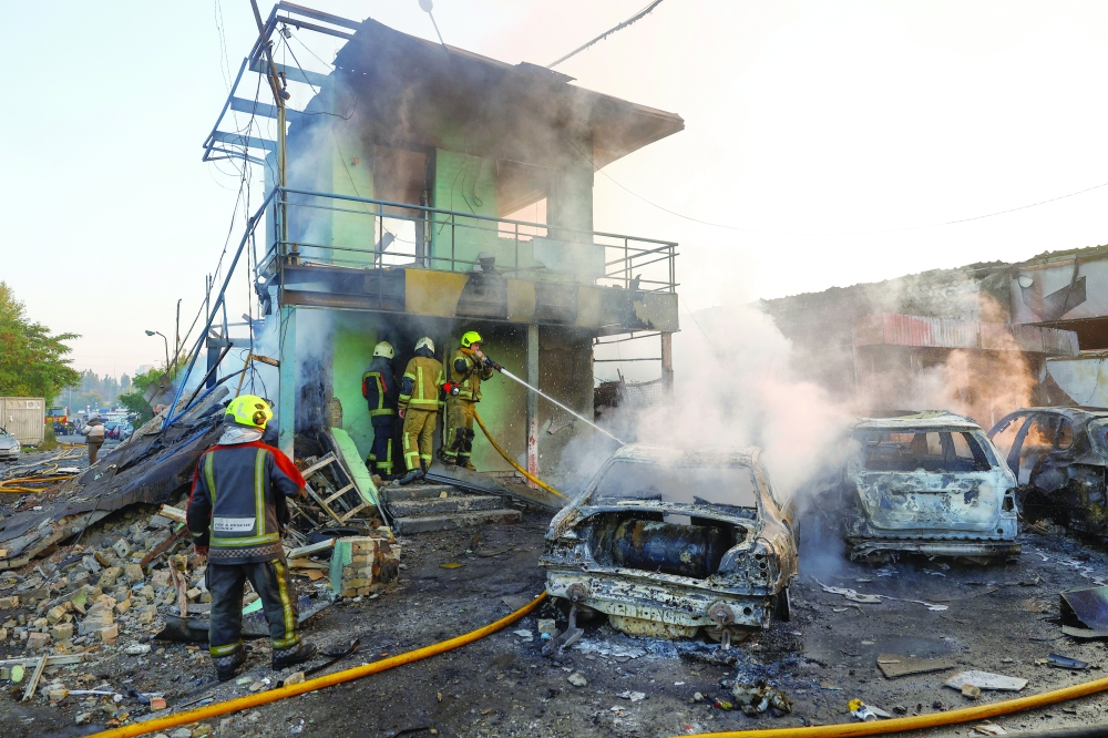 Firefighters work at the site of private car garages hit by a Russian missile strike in Kyiv. — Reuters 