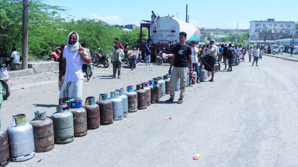 People queue with cooking gas cylinders amid shortages of supply in Taiz. — Reuters 
