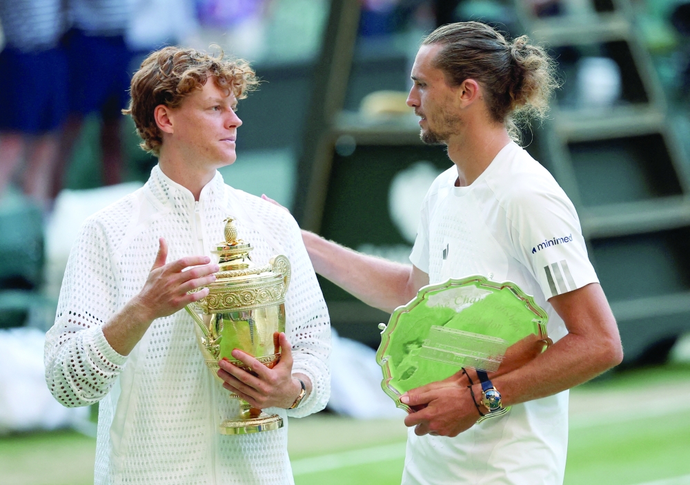 Italy's Jannik Sinner celebrates with the Wimbledon trophy as Germany's Alexander Zverev holds the runner-up trophy after their final in London on July 12, 2026. — Reuters