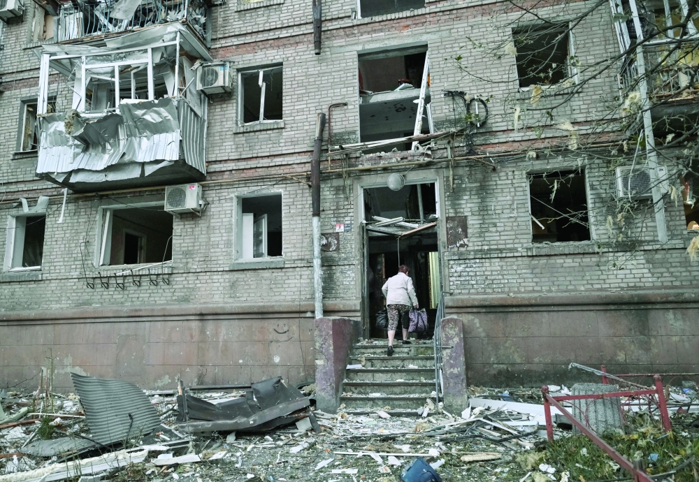 A resident enters an apartment building that was damaged during a Russian air strike, amidst Russia's attack on Ukraine in Zaporizhzhia, Ukraine. — Reuters