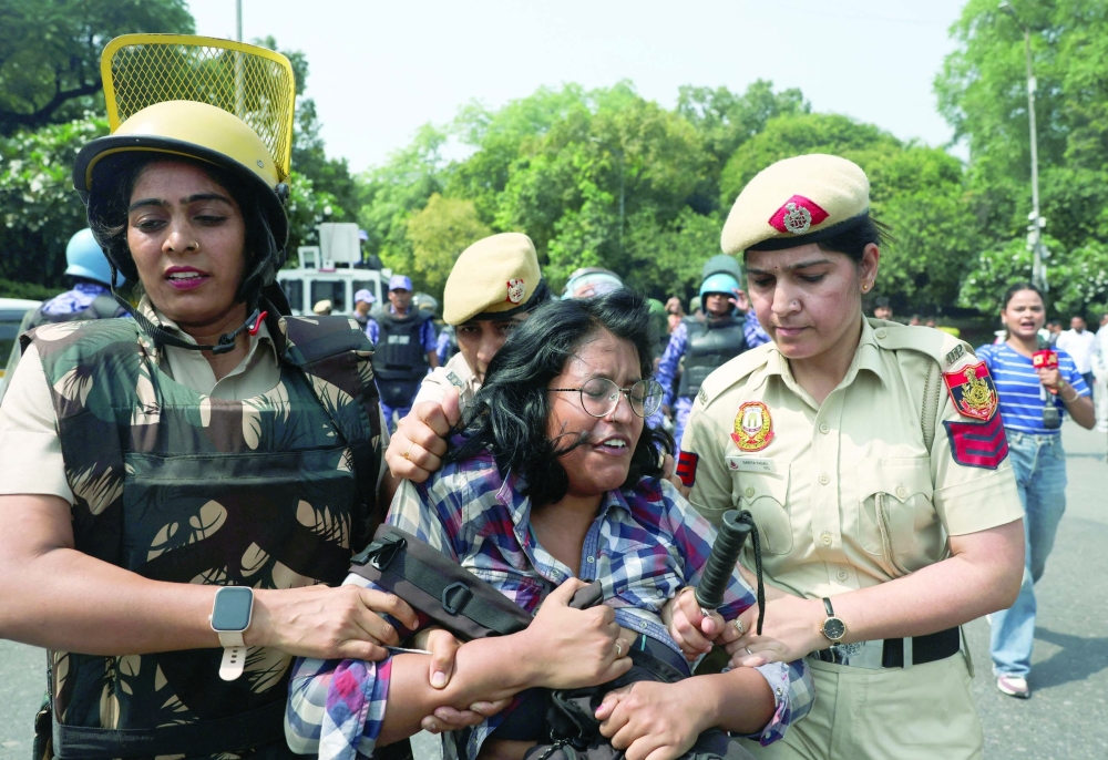 Security personnel detain a supporter of the Cockroach Janta Party (CJP) during a protest in New Delhi. — Reuters
