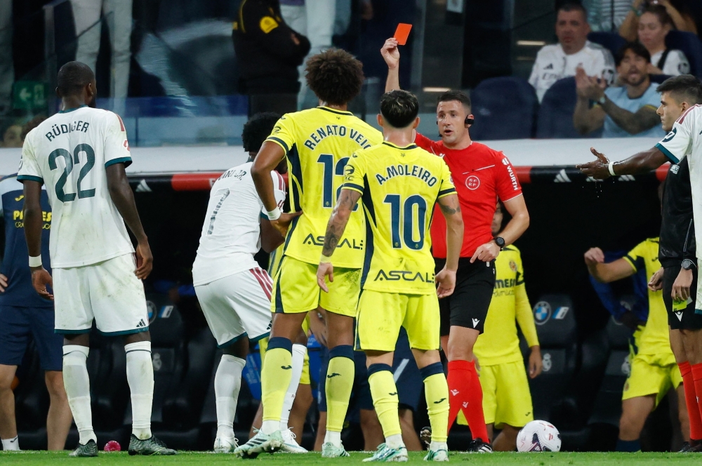 Referee Isidro Escuderos shows a red card to Real Madrid's Brazilian forward #07 Vinicius Junior (2L)  