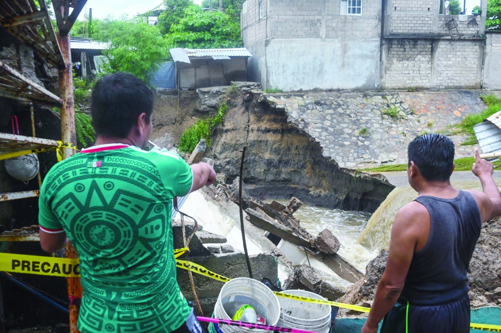 Residents watch the damage caused by heavy rains following the arrival of Hurricane Simon in Acapulco, Mexico. — AFP