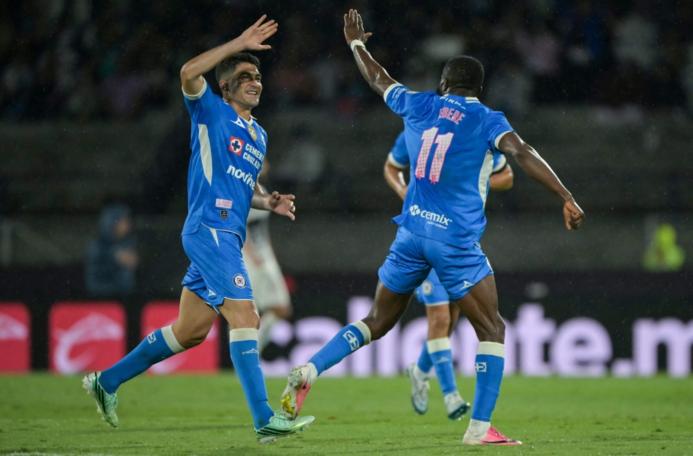 Cruz Azul's Nigerian forward #11 Christian Ebere (R) celebrates scoring his team's third goal  