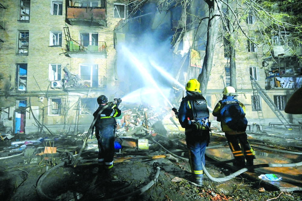 Ukrainian firefighters extinguish a blaze at the site of a Russian drone strike at a multi-floor building in Kharkiv. — AFP