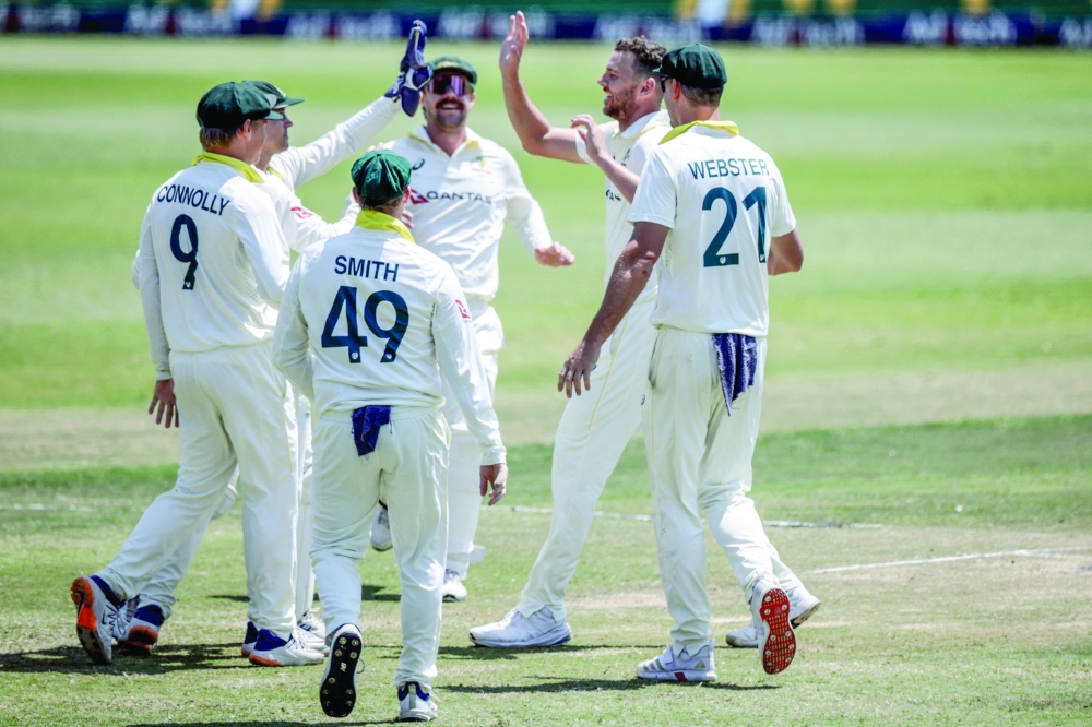 Australia's Josh Hazlewood (2nd R) celebrates with his teammates after dismissing South Africa's Wiaan Mulder on day five of the first Test match between South Africa and Australia at the Kingsmead stadium in Durban on October 13, 2026. (Photo by Marco Longari / AFP)
