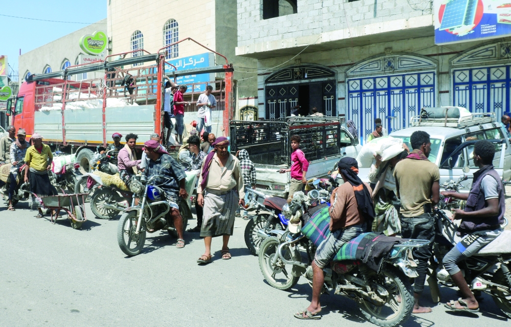 People crowd outside a shop to buy sacks of wheat flour in Taiz, Yemen. — Reuters