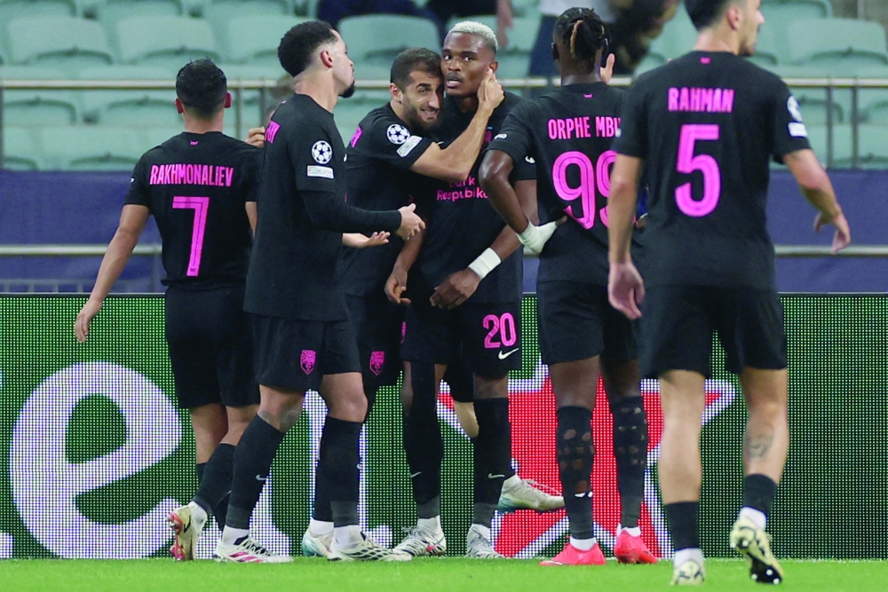 Sabah FK's Rwandan forward #20 Joy-Lance Mickels celebrates with teammates after scoring the team's second goal during the UEFA Champions League match between Sabah and Slavia Praha at the Baku Olympic Stadium in Baku on October 13, 2026. (Photo by Giorgi ARJEVANIDZE / AFP)
