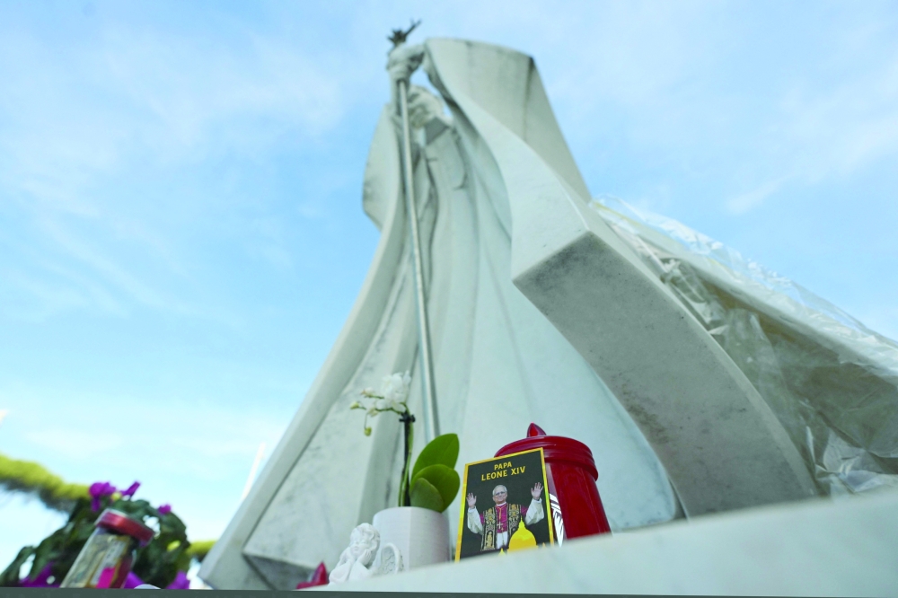 A picture of Pope Leo is laid at the statue of John Paul II outside Rome’s Gemelli Hospital, where the pope is recovering after lung surgery. — AFP