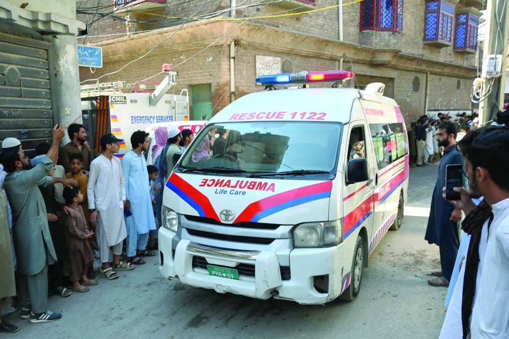 An ambulance carrying children leaves the site of a school roof collapse in Peshawar on Thursday. — AFP