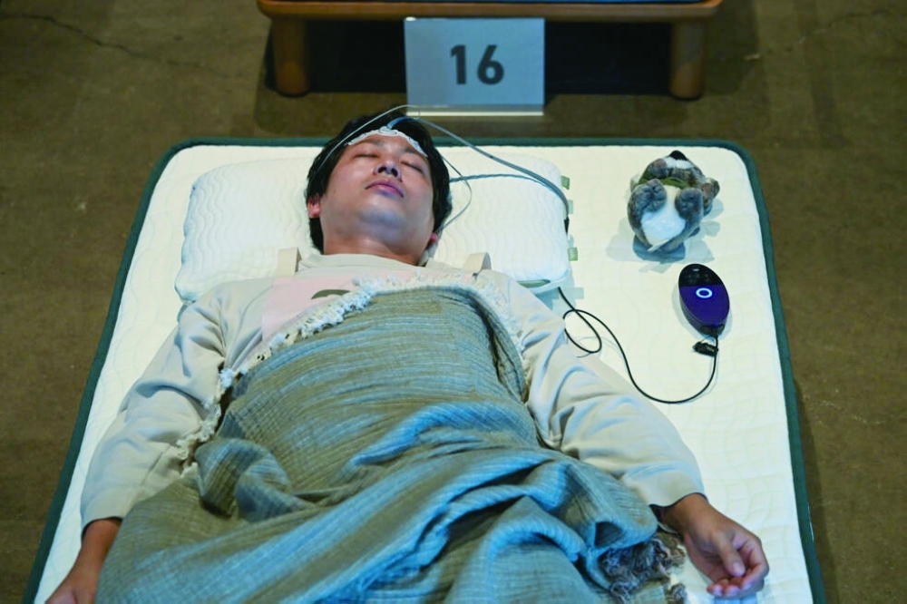 Competitors nap on mattresses while wearing sleep-tracking devices.