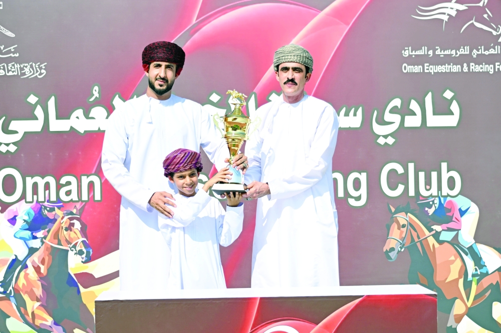 A winner being presented with the trophy.  — Mohammed al Balushi