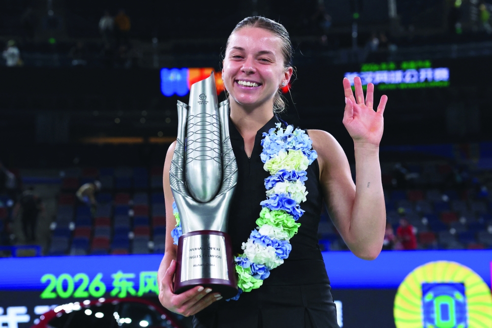 Poland's Maja Chwalinska celebrates with the trophy after winning her singles final match against Britain's Sonay Kartal. — Reuters