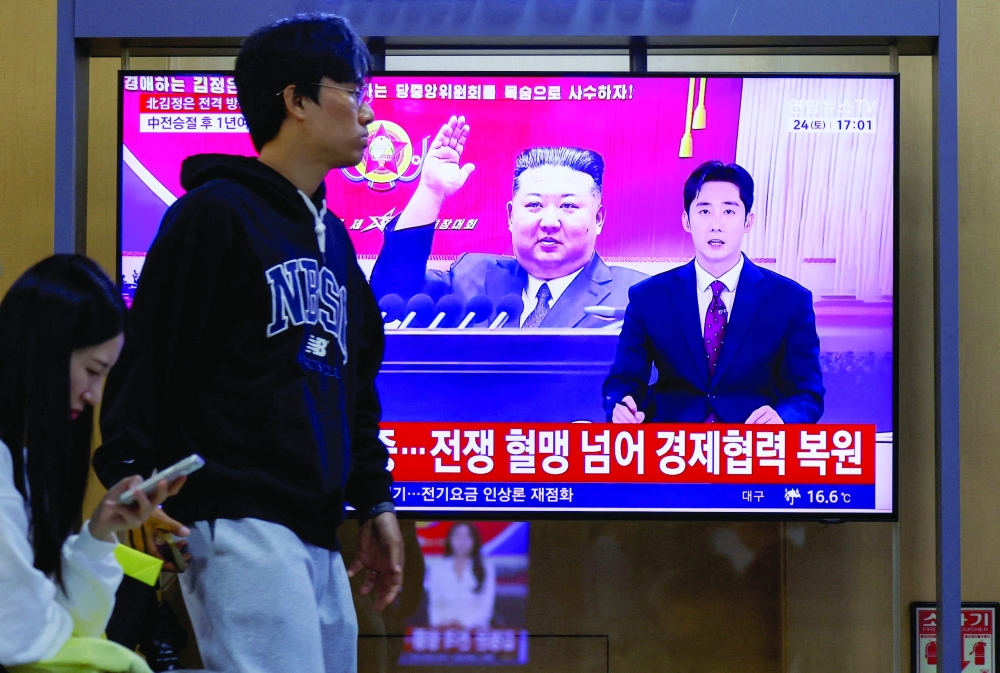 A man passes by a TV showing a news report on North Korean leader Kim Jong Un's visit to China at a railway station in Seoul. — Reuters 