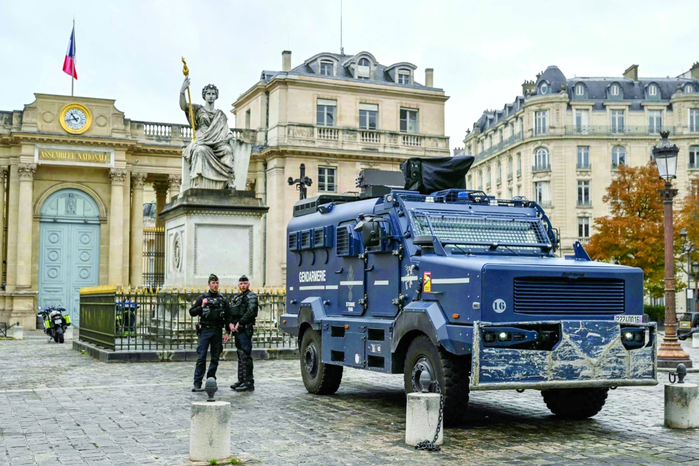 French gendarmes stand next to a multipurpose intervention vehicle with the National Assembly building in the background in Paris. — AFP 
