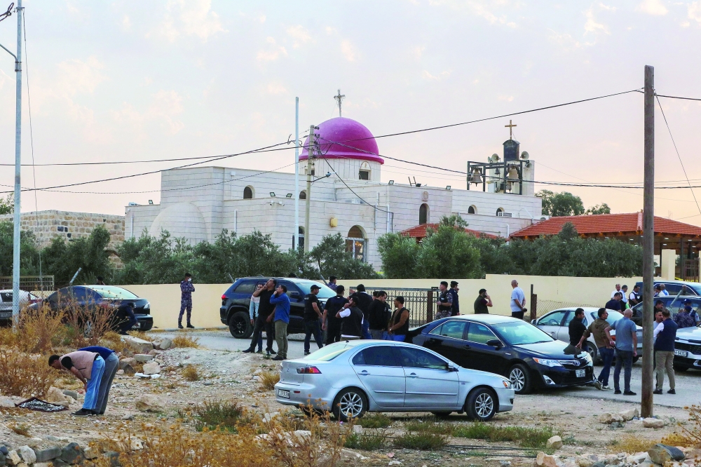 People and security forces gather outside a Greek Orthodox Church in the village of Hammoud village in Jordan's Karak governorate following a shooting on October 23, 2026. Gunmen killed at least seven people and wounded 10 more in an attack on a church in southern Jordan on October 23, authorities said. Two assailants stormed the compound of a Greek Orthodox church in the village of Hammoud in Karak governorate before opening fire, the public security directorate said in a statement. (Photo by AFP)
