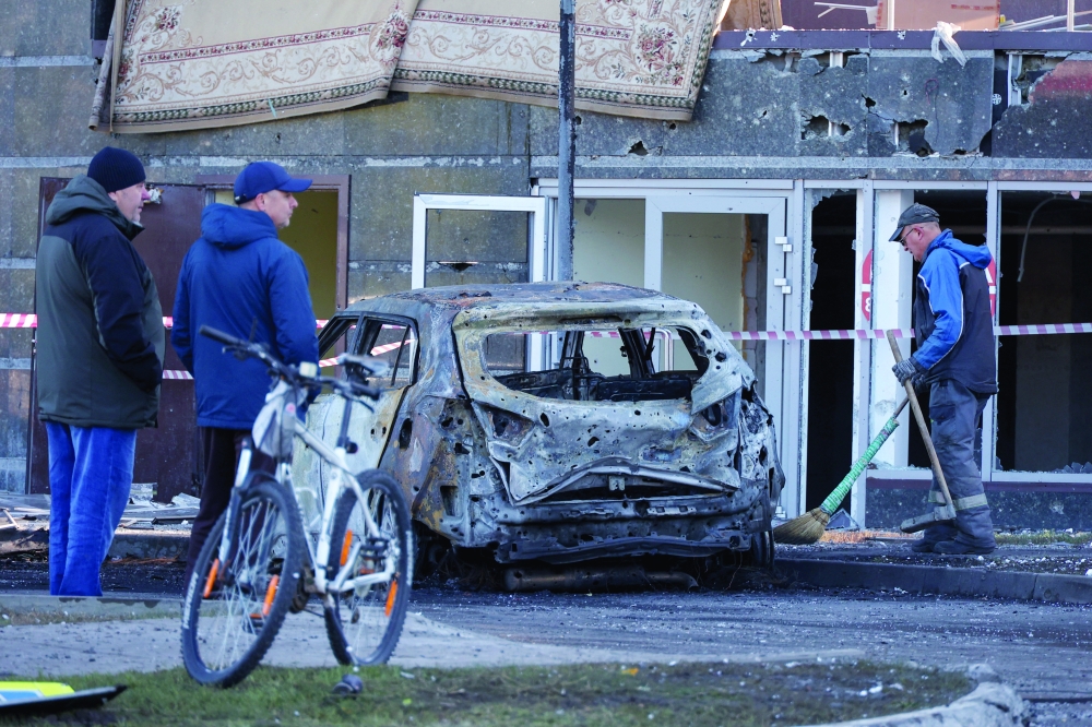 People gather outside a residential complex hit by what local authorities described as a Ukrainian overnight drone strike, amid the Russia-Ukraine conflict, in central Belgorod, Russia, October 25, 2026. REUTERS/Stringer