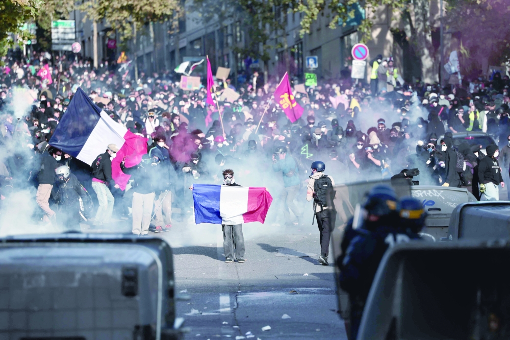 Protesters hold French national flags as they confront French officers during a demonstration in Marseille. — AFP