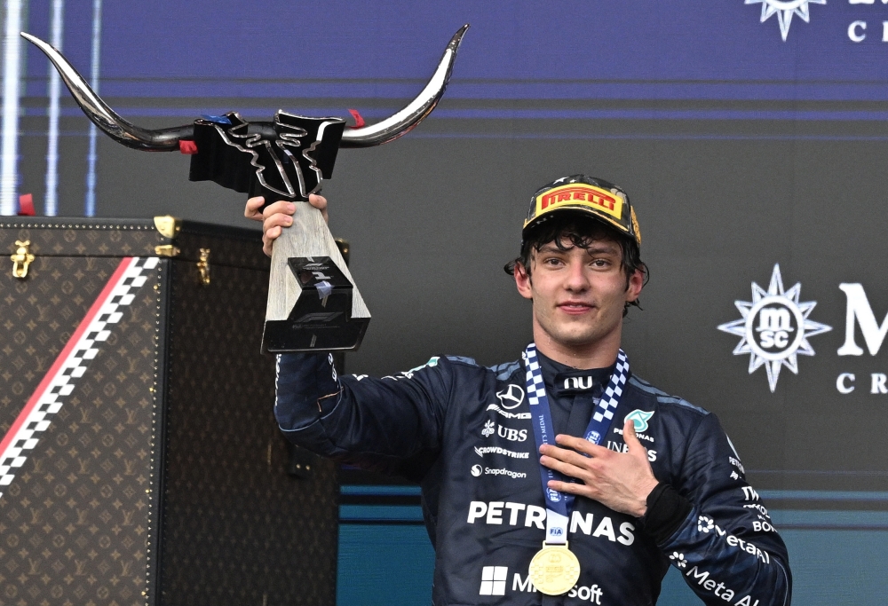  
Mercedes' Andrea Kimi Antonelli celebrates with the trophy on the podium 
