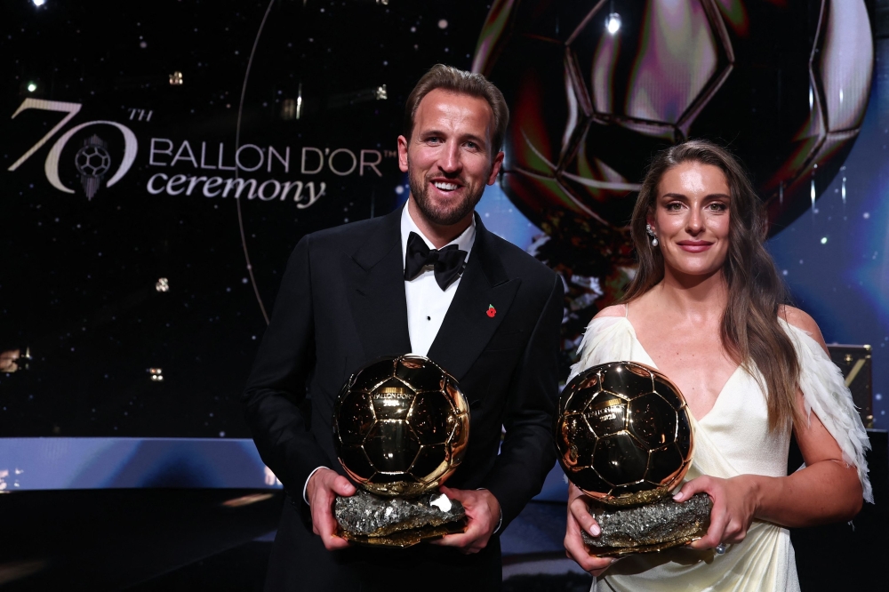 Spain and Barcelona midfielder Alexia Putellas and England and Bayern Munich forward Harry Kane pose with their trophies on stage after receiving their Ballon d'Or awards 