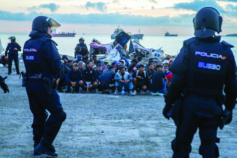 Migrants are organized into groups as they are removed by police in Spain's north African enclave of Ceuta. — AFP