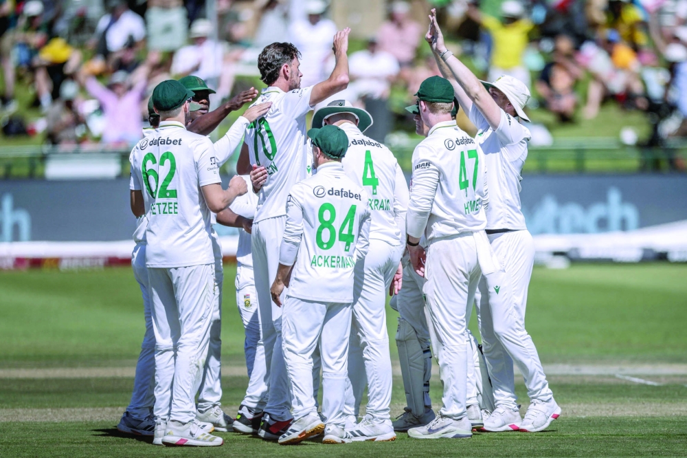TOPSHOT - South Africa's Marco Jansen (C) celebrates with teammates after the dismissal of Australia's Matt Renshaw during day two of the third Test match between South Africa and Australia