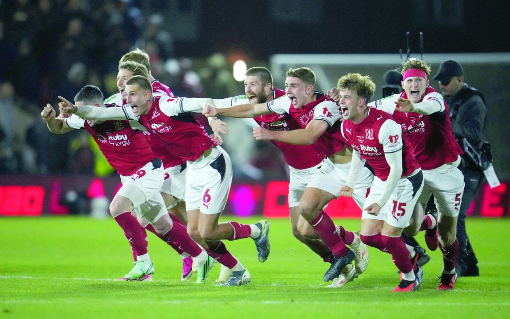 Fleetwood Town's Rhys Bennett and teammates celebrate winning the penalty shoot-out against Arsenal