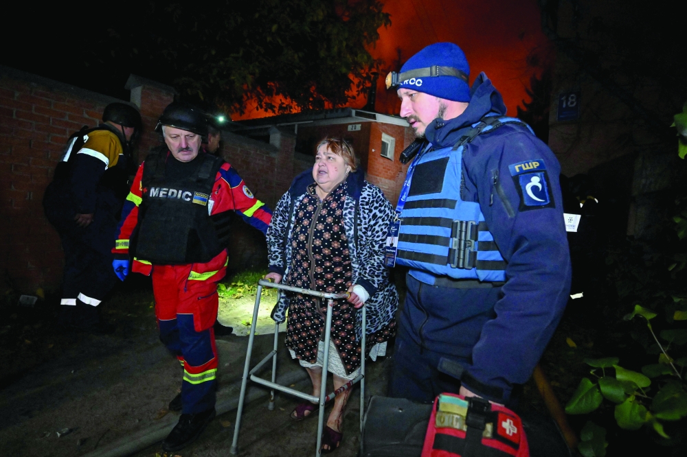 Ukrainian paramedics help a resident at the site of a Russian drone strike in Kharkiv