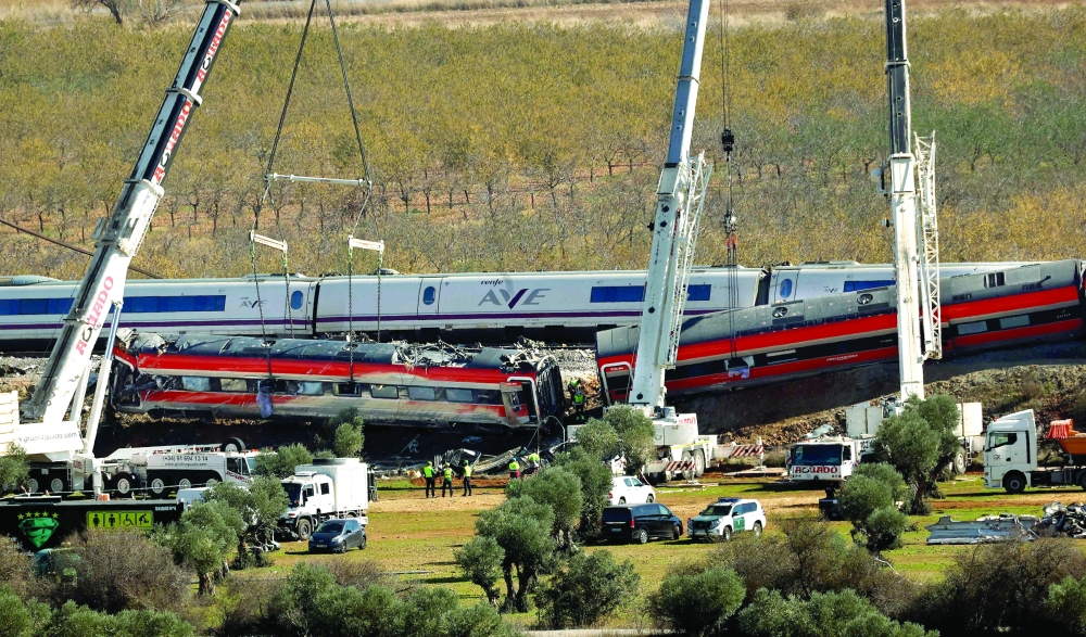 Huge cranes lift one of the wrecked carriages of a train crash between a Renfe AVE train and an Iryo train in the province of Toledo. 