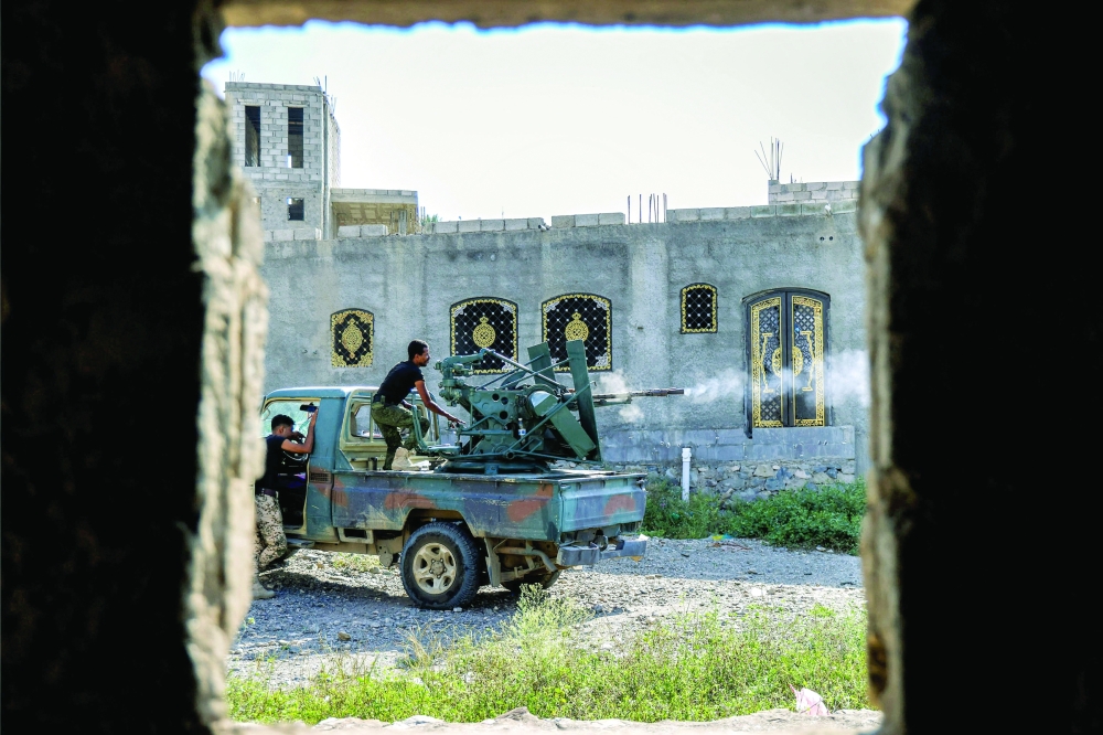 A fighter fires a turret from the back of a pickup truck at a position along the frontlines in Yemen's western Taiz province. — AFP