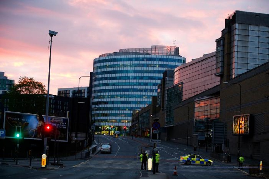 The sun rises as police stand guard outside the Manchester Arena in Manchester
