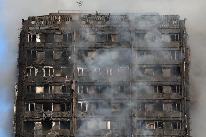 Smoke billows from a tower block severly damaged by a serious fire, in north Kensington, West London