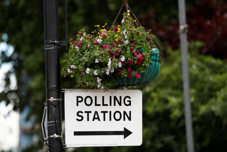 A sign to a polling station hangs from a lamp post in central London