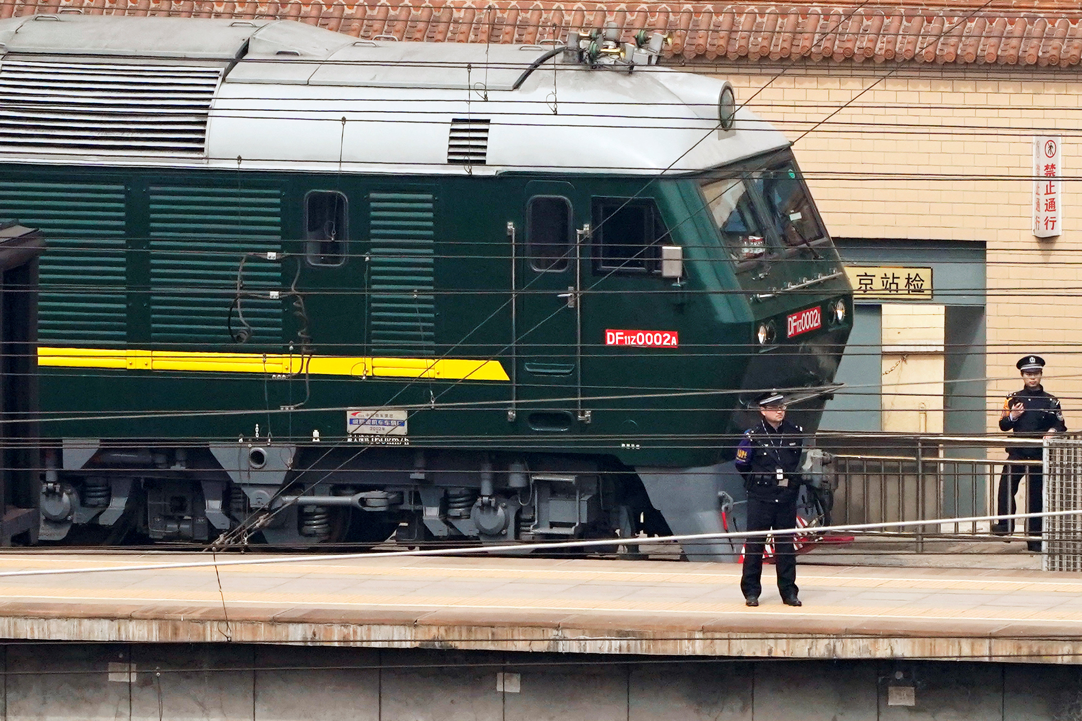 Police officers keep watch next to a train at the Beijing Railway Station in Beijing