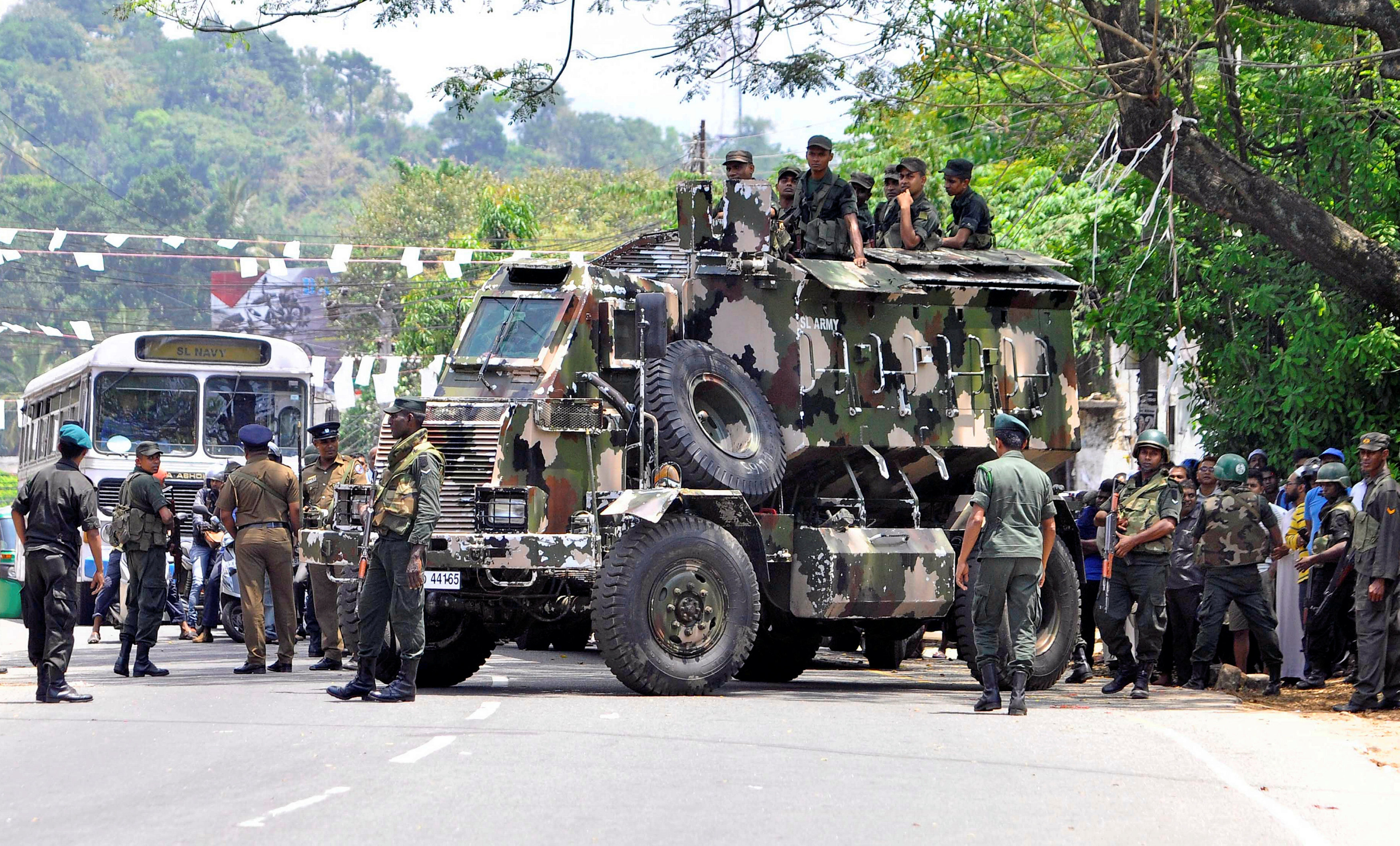 Sri Lanka's army soldiers stand guard a road after a clash between two communities in Digana