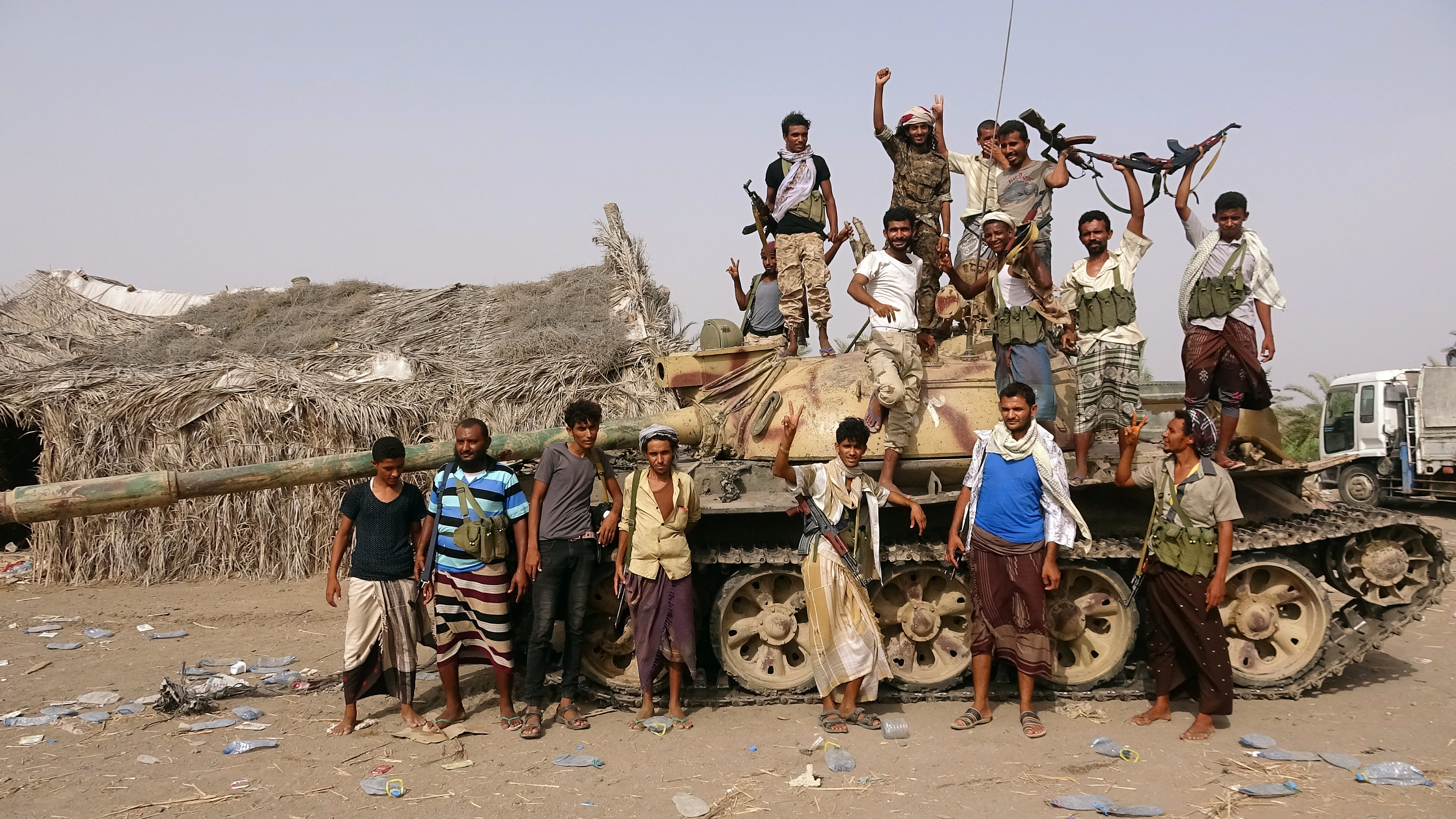 Tribal fighters loyal to the Yemeni government stand by a tank in al-Faza area near Hodeida