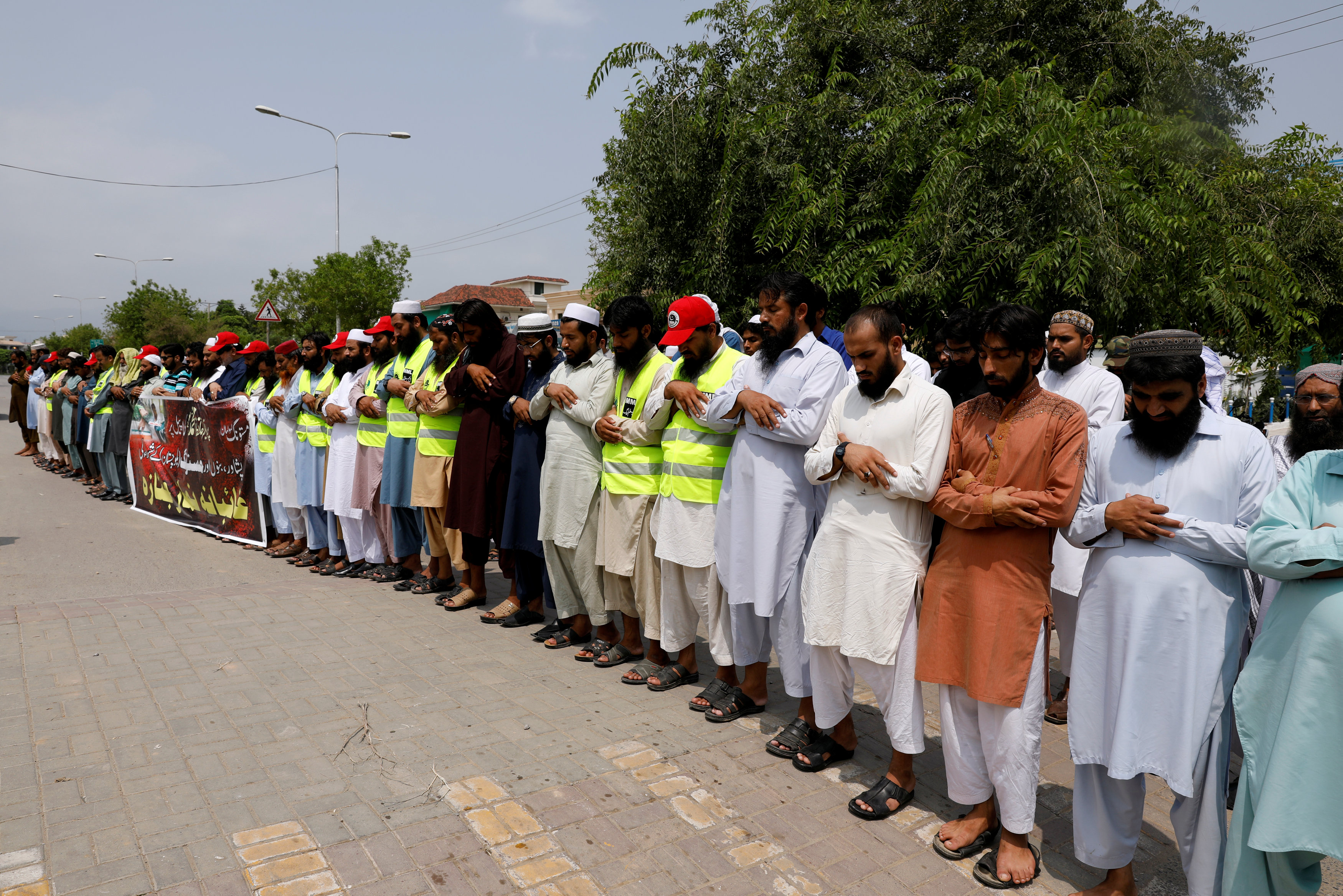 Supporters of the Jamaat-ud-Dawa Islamic organization offer funeral prayers in absentia for the victims of Friday's suicide attack at an election rally in Mastung, outside a mosque in Islamabad