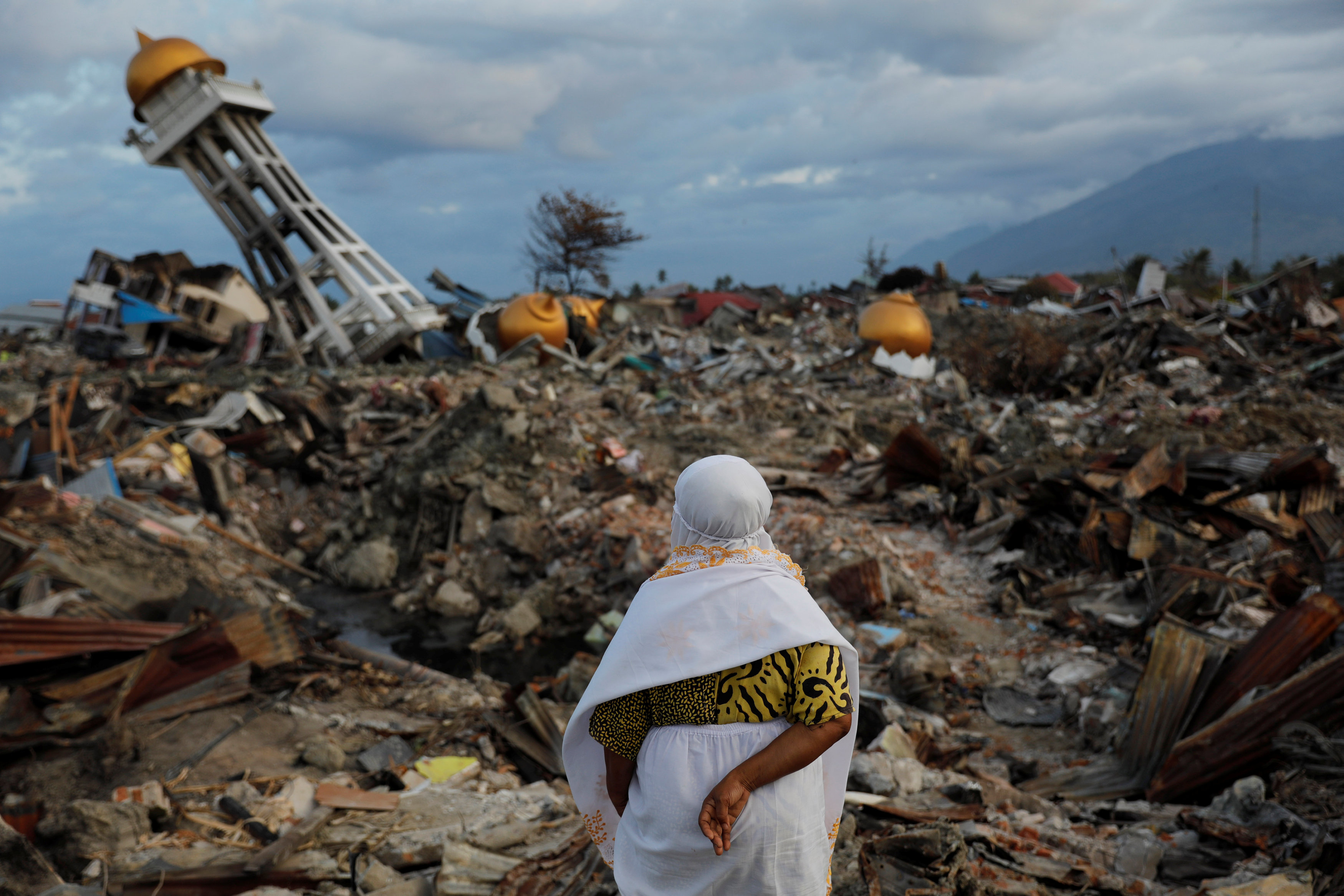 A woman who lost her nephew in last week's earthquake stands in the Balaroa neighbourhood in Palu