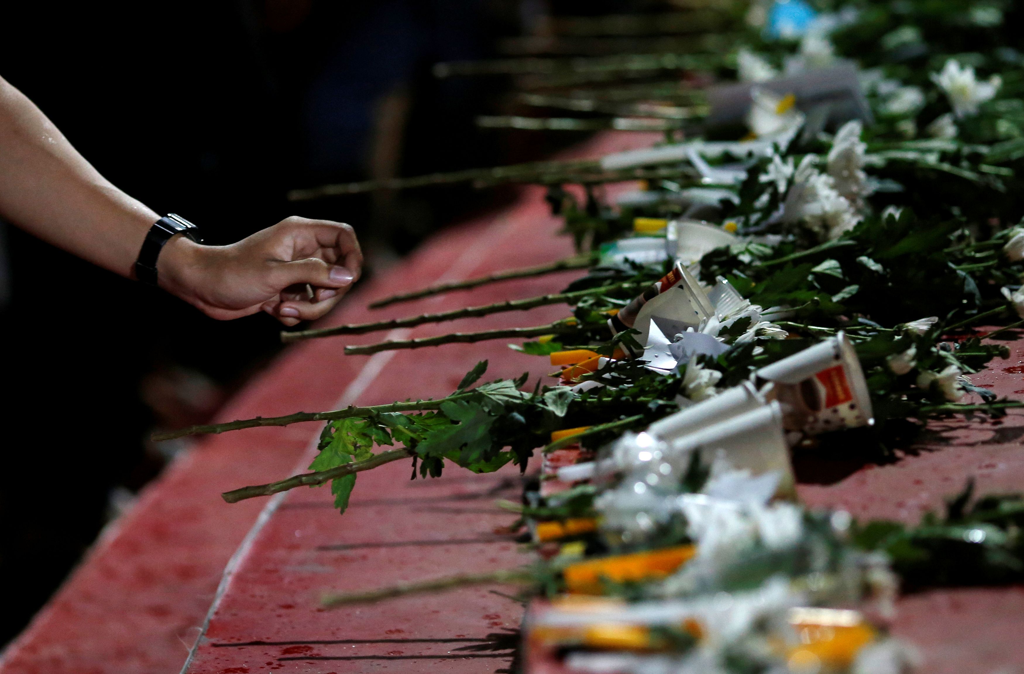 Local people place flowers as they pray for victims who died in mass shooting, involving a Thai soldier on a shooting rampage, in Nakhon Ratchasima